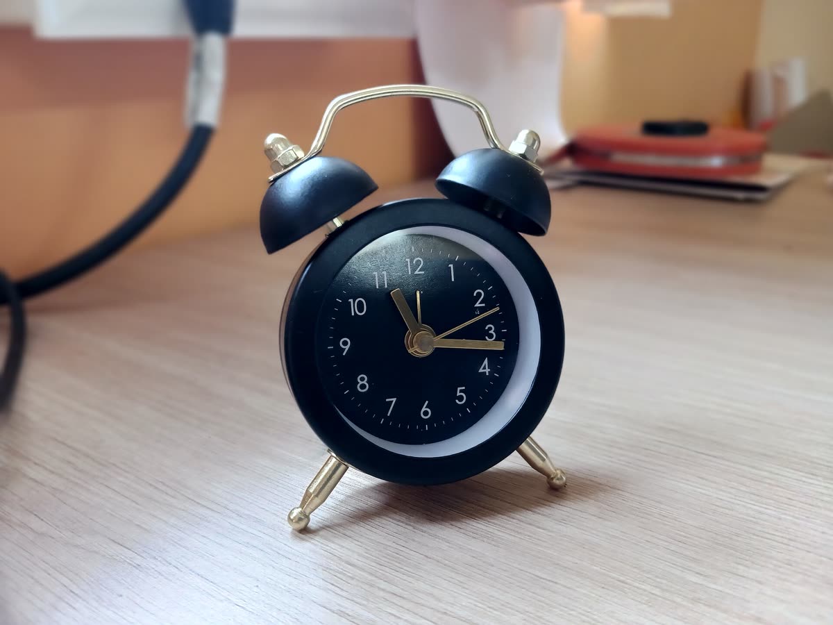 Small black alarm clock on a desk — LISA SaWaDiKa release time: 9:00 AM KST September 4, 8 PM EDT September 3