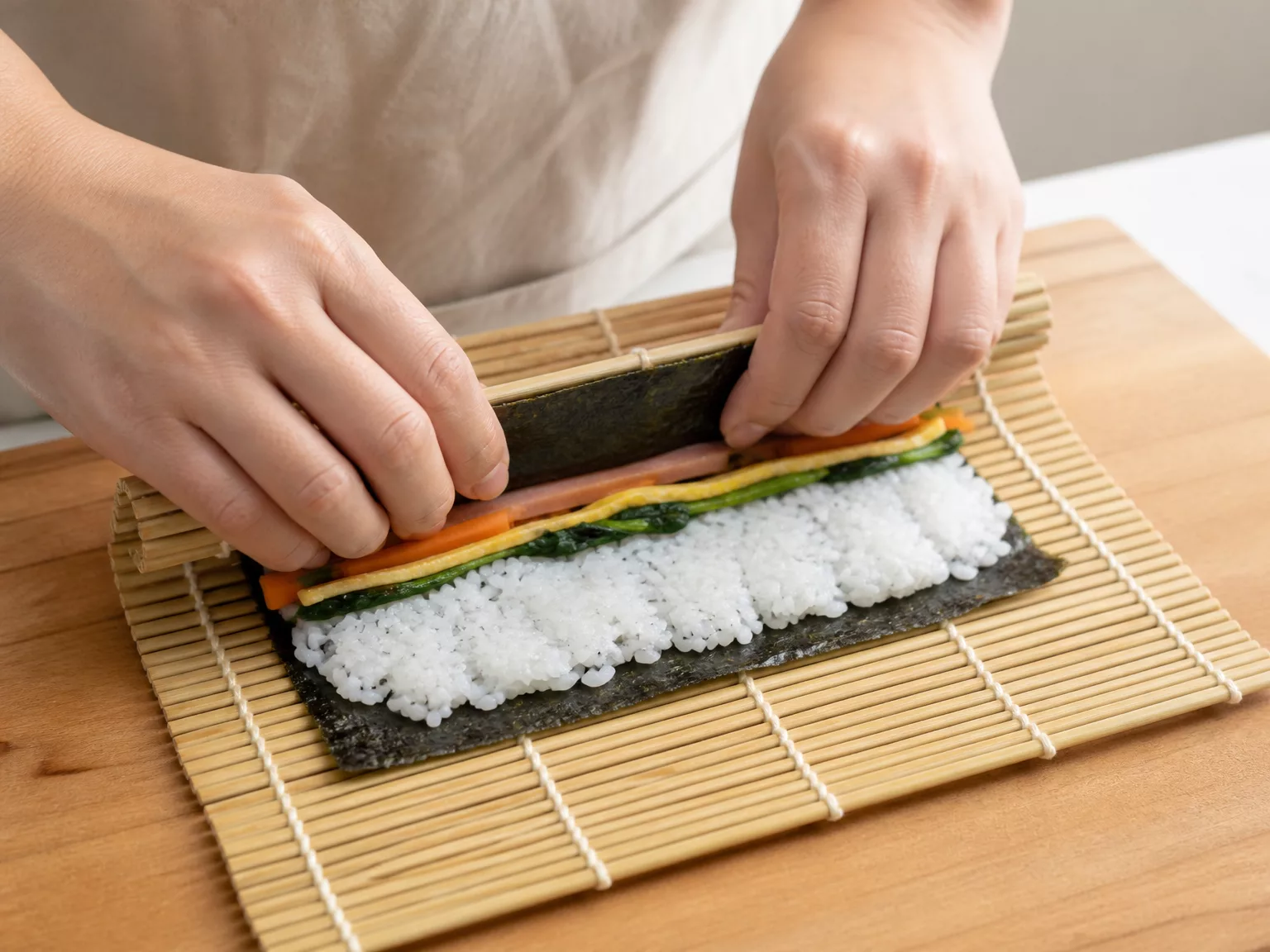 Step 4: Roll tightly away from you, lifting the near edge over the fillings…